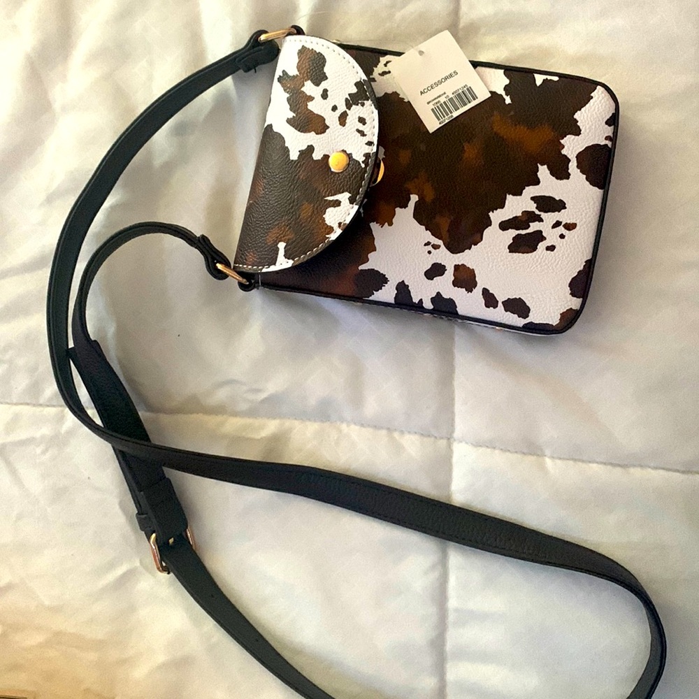Cow print purse with one pocket.